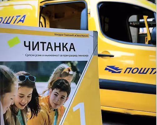 Čitanka (Srpski jezik i književnost za prvi razred gimnazije) naslonjena na poštansko vozilo „Pošta".